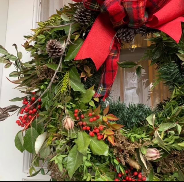 Festive holiday wreath with pinecones, berries, and a red bow at Port of Leonardtown Winery.